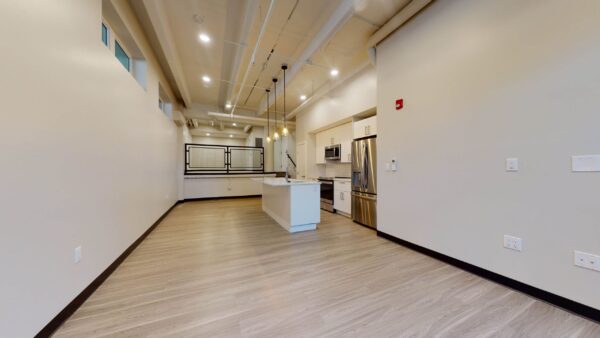 one bedroom apartment with lofted bedroom area and large kitchen with an island sink and stainless steel appliances
