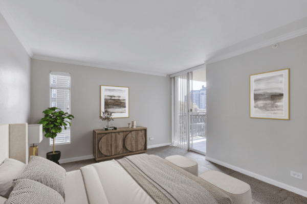 large bedroom with bed, dresser, and entry to balcony