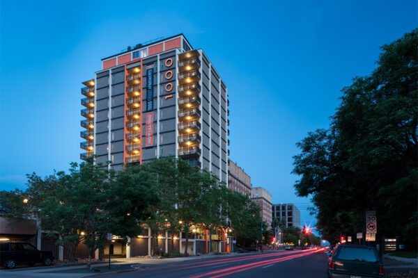 1000 Grant exterior at dusk showing modern architecture and tall trees.