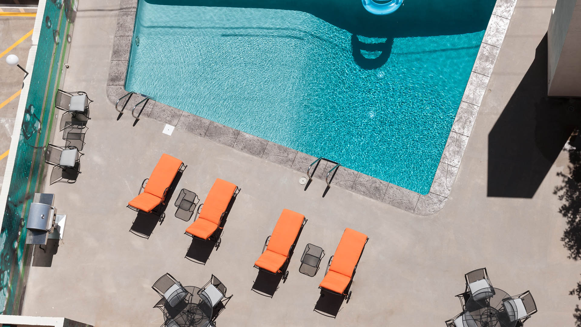 Aerial view of 1000 Grant swimming pool with lounge chairs and dining tables.