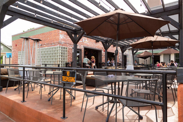 Restaurant patio with pergola and umbrellas.