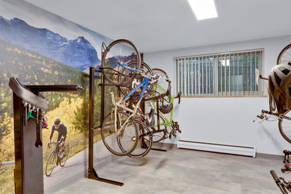 Bike repair room with bike stand and large mural depicting bike rider in mountains.