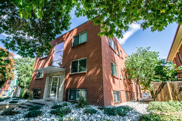 1136 York apartments with brick construction, large windows, and tall trees.