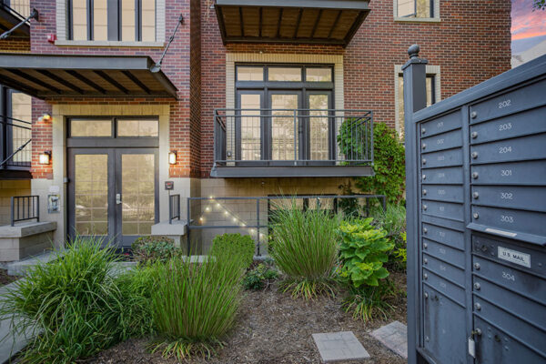 1145 Ogden apartment building with lush landscaping, large balconies, and mailboxes.