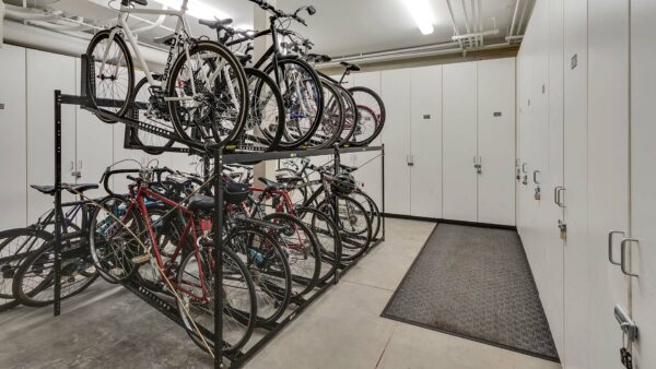 Bike storage room with lockers and tall bike racks.