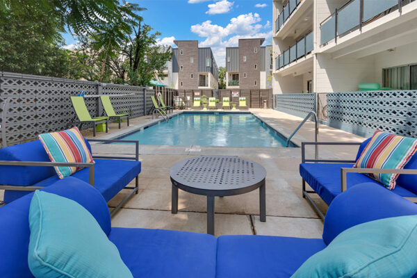 1190 Birch pool area with plush outdoor furniture and lounge chairs overlooked by apartment balconies.
