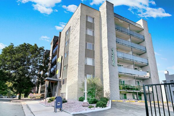 1265 Downing apartments with brick construction and tall trees.