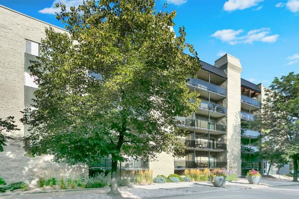 1265 Downing apartments with brick construction and tall trees.