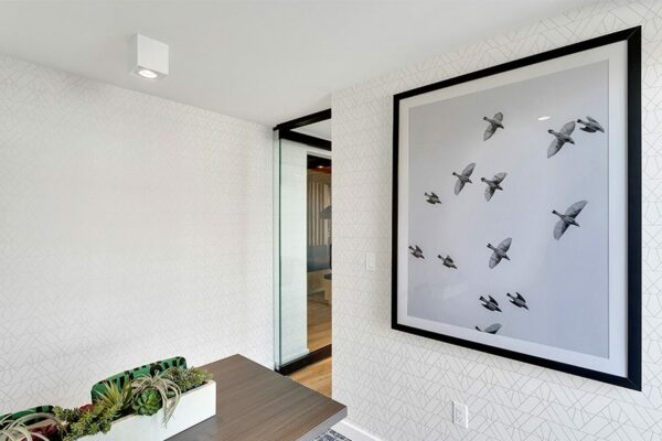 Meeting room with wood table, planter with succulents, and large photo of birds.
