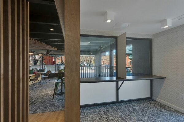 Lounge with carpet, rich wood paneling, and large windows.