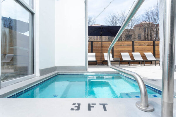 Detail of outdoor hot tub with metal railing.