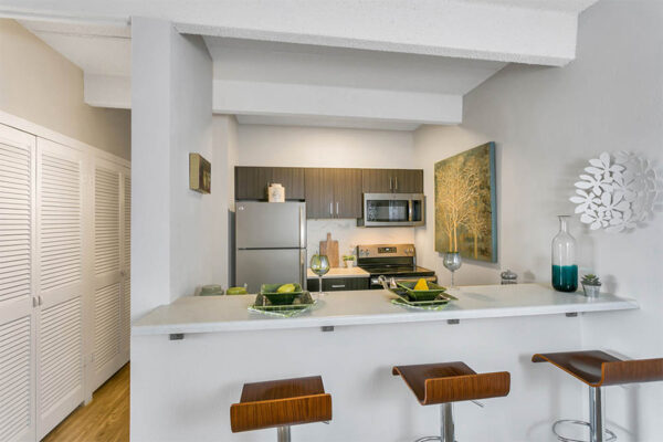 Breakfast bar with place settings and tall stools with opening to kitchen.
