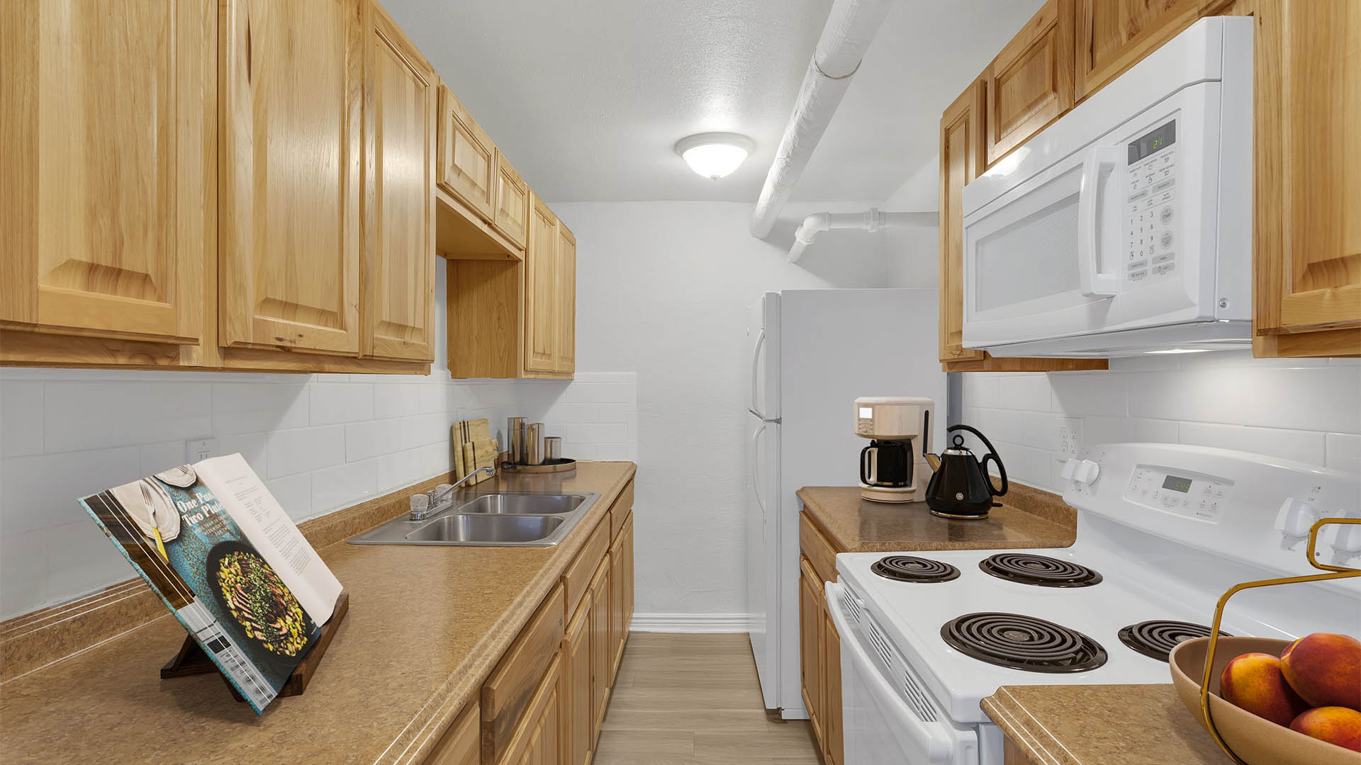 1357 & 1373 Cook kitchen with wood cabinets, stone counters, and white appliances.