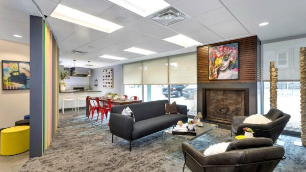 Lounge with carpet, plush seating, fireplace, artwork, and large windows.