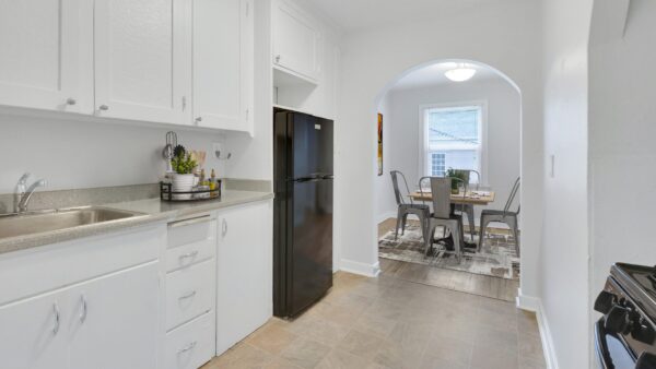 kitchen with refrigerator, sink, and stove with view to dining area