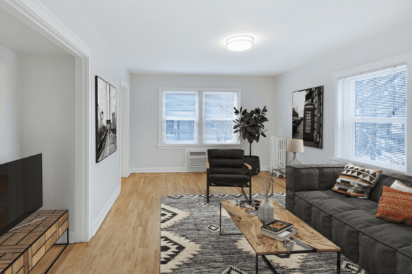 Livingroom with large window, couch and coffee table with entrance to kitchen
