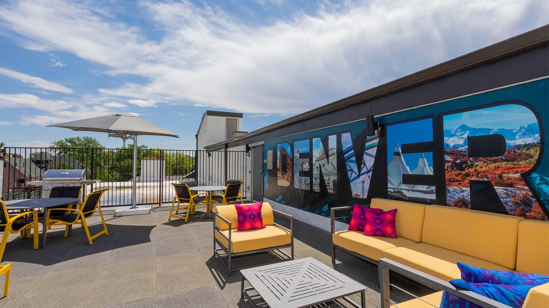 Rooftop patio with comfortable lounge chairs and painted Denver mural.
