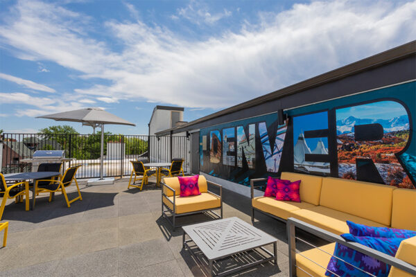 Rooftop patio with plush outdoor sectional and Denver mural.