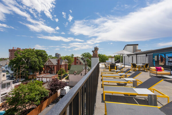 Rooftop patio with lounge chairs overlooking Denver.