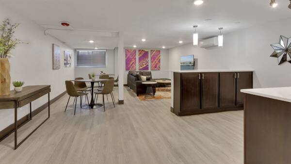 Living area with wood floors, dining table, modern furniture, and lighting fixtures.