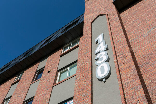 Signage for 1430 Humboldt with brick construction and apartment windows.