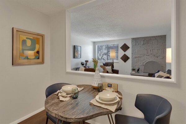 Living and dining room with half wall, live edge wood dining table, and plush seating.