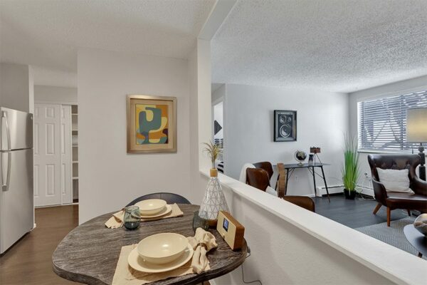 Living and dining room with half wall, live edge wood dining table, and plush seating.