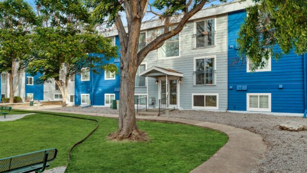 Exterior of The Flats at Creekside with apartments surrounded by grass, sidewalks, and trees.