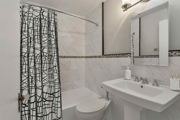Bathroom with white tile walls and shower tub.