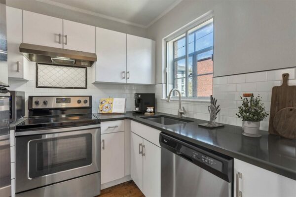 Kitchen with white cabinets, gray counters, and stainless steel appliances.