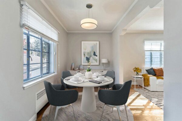 Dining room with round table, modern chairs, and large window.