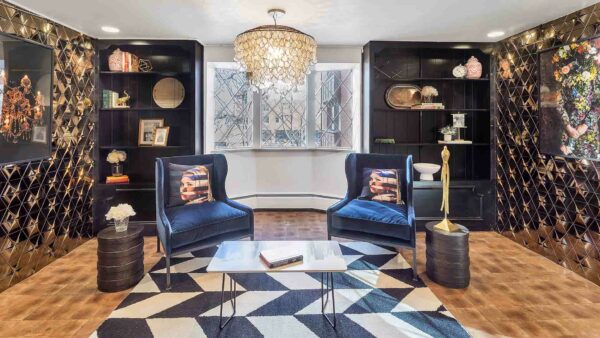 Lounge with geometric rug, plush lounge seating, and chandeliers.