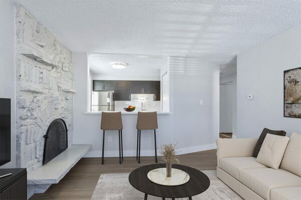 Apartment living room with modern furniture, fireplace, and breakfast bar.