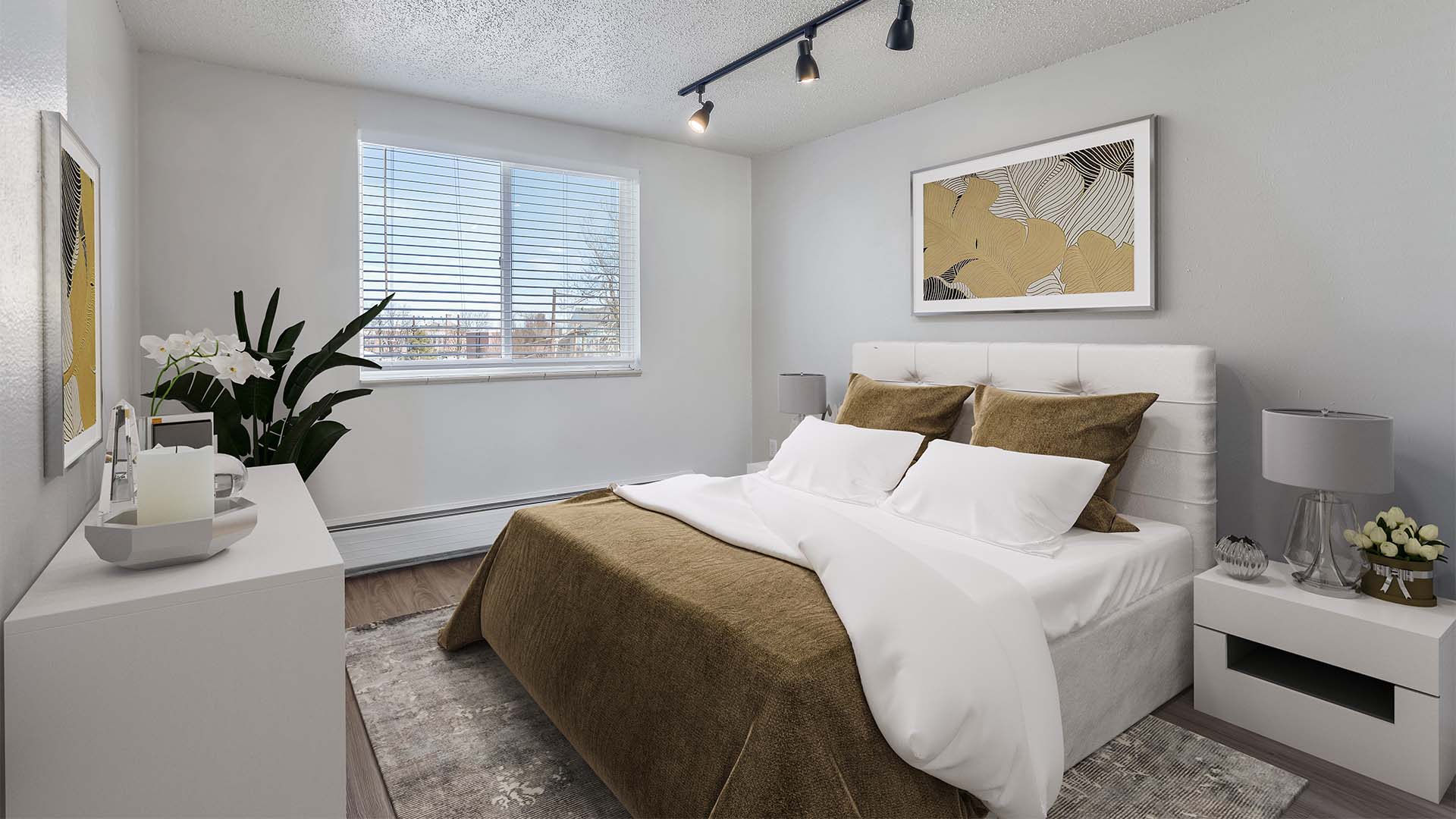 Apartment bedroom with plush bed, framed art, and large window.