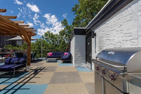 Outdoor patio with lounge chairs and a grill.
