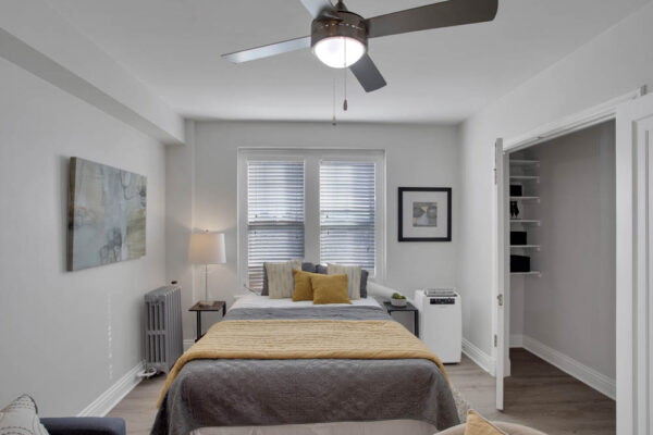 one bedroom apartment bedroom with bed in the middle and large window behind