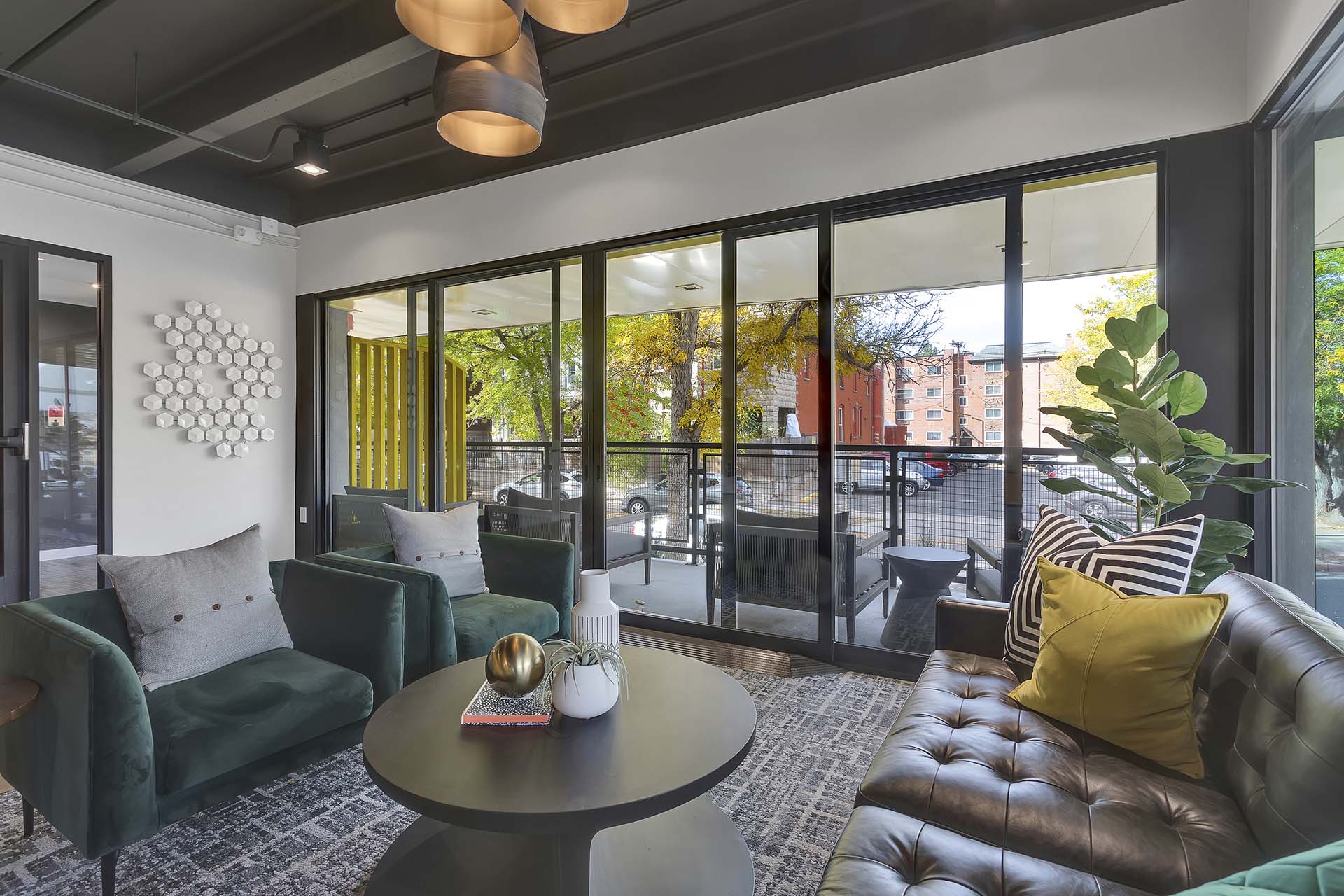 Lounge with geometric carpet, plush seating, eclectic decor, and large window.