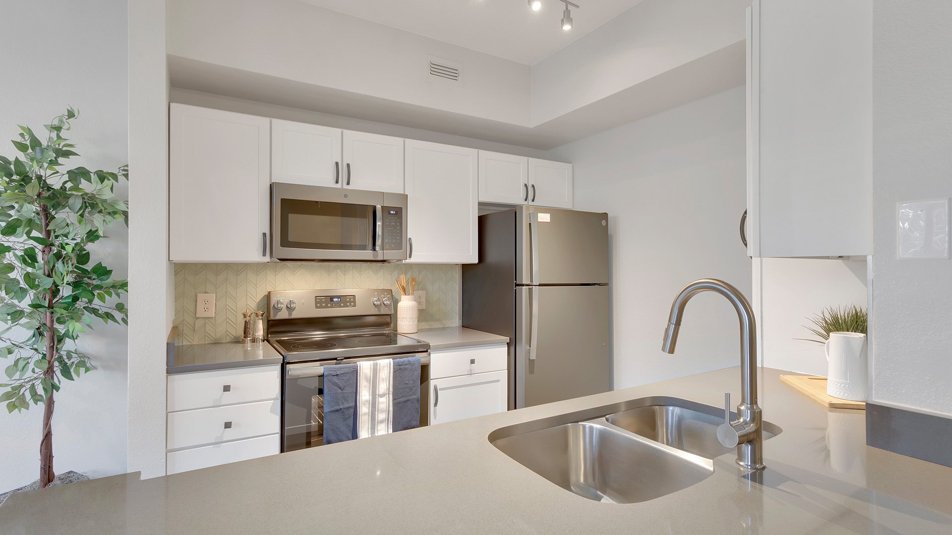 Kitchen with white cabinets, gray countertops, and stainless steel appliances.