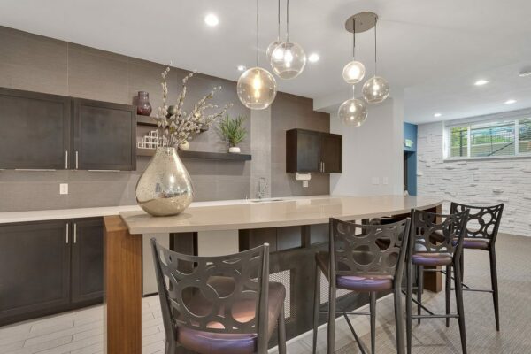 Demo kitchen with tile floor, stone counters, dark cabinets, and stainless steel appliances.