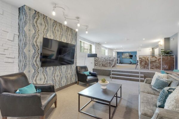 Lounge with plush seating, modern furniture, and wall mounted TV.