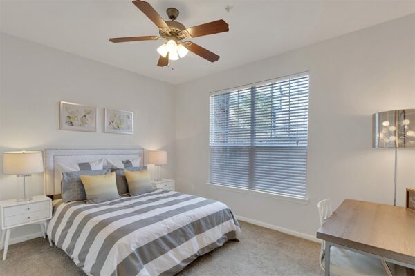 Apartment bedroom with queen size bed and window.
