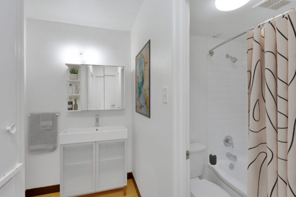 bathroom with bathtub and sink with white cabinets