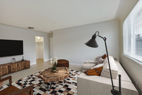 one bedroom apartment living room with couch, coffee table, tv, and large window