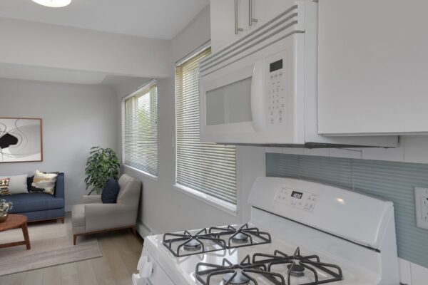 kitchen with view of oven and the living room couch in the background