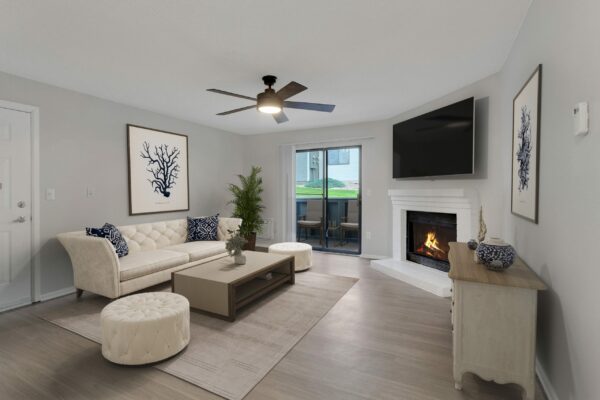 Living room with wood floor, eclectic furniture, framed artwork, fireplace, and door to balcony.