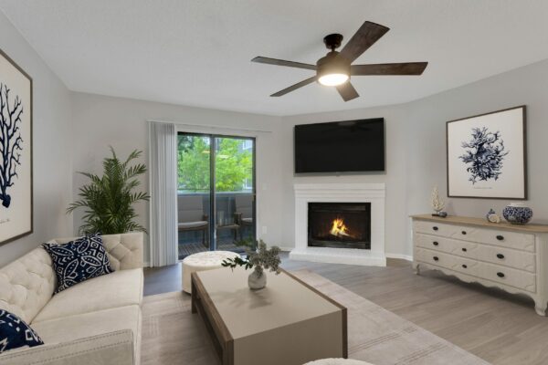 Living room with wood floor, plush couch, eclectic decor, and fireplace with TV.