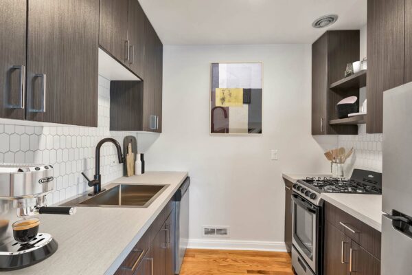Kitchen with dark wood cabinets, white countertops, and wood floors.