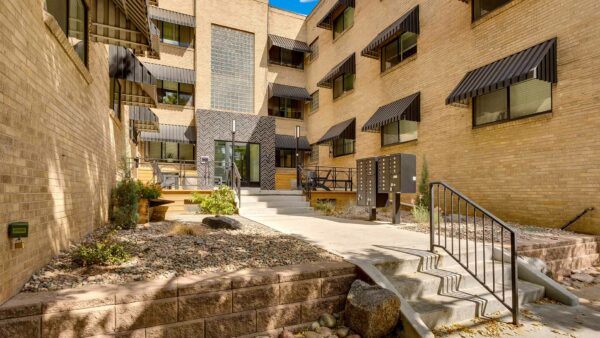 611 East 11th apartment courtyard with rocky landscaping, outdoor patio, and mailboxes.