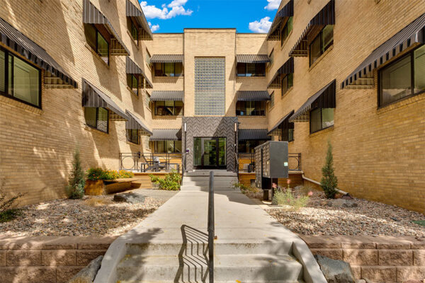 611 East 11th courtyard with mailboxes, glass entrance door, and large windows.