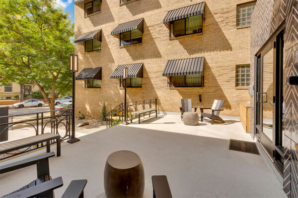 611 East 11th courtyard with outdoor lounge seating, glass entrance door, and large windows.
